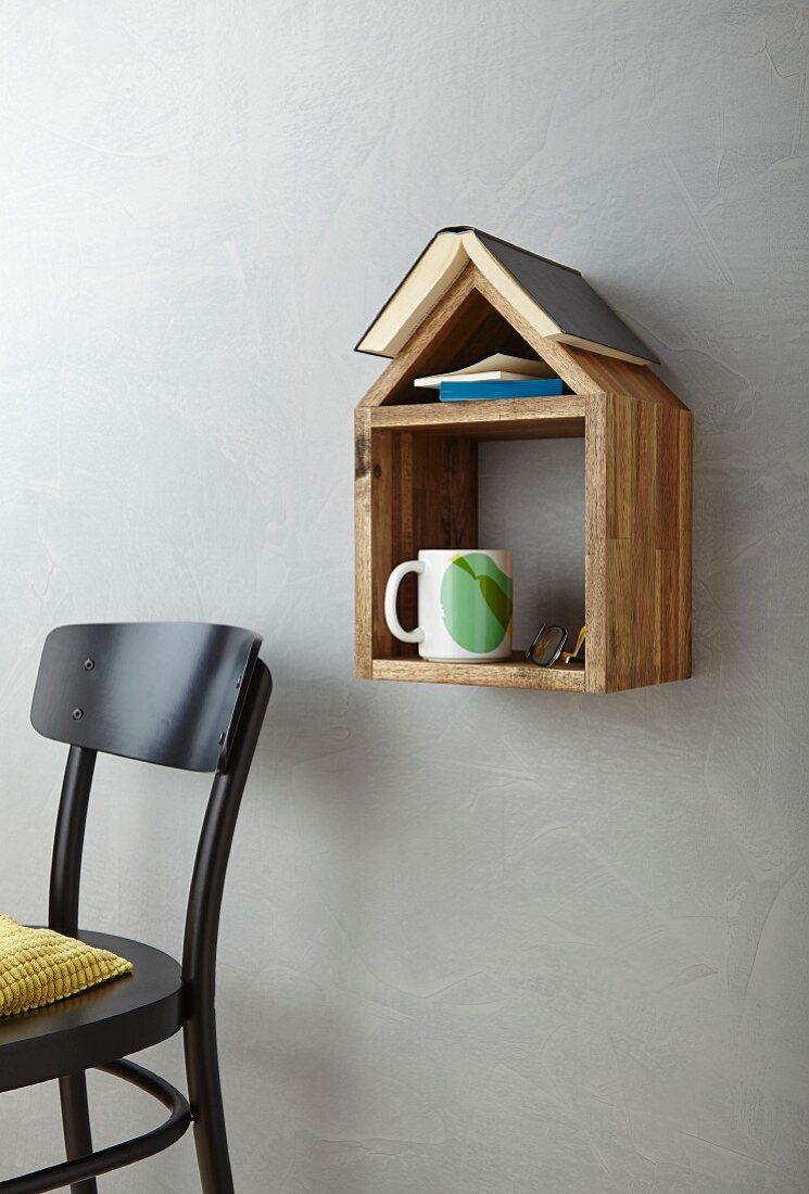 DIY-Holzhäuschen als Ablage für Bücher, Tasse und Brille, neben Stuhl