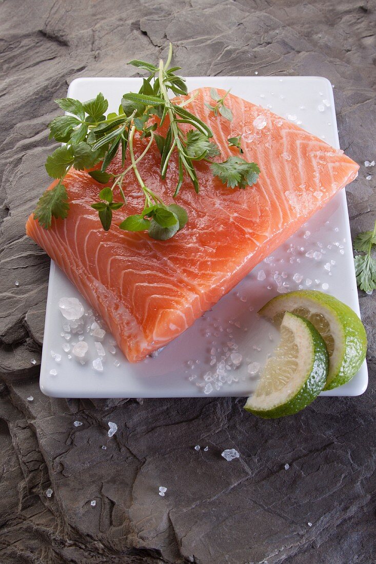 Raw salmon fillet with herbs, salt and lime