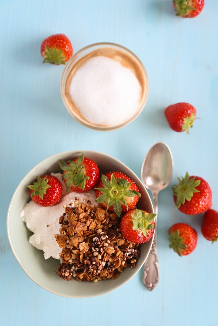 Müsli mit Erdbeeren und Cappuccino zum Frühstück