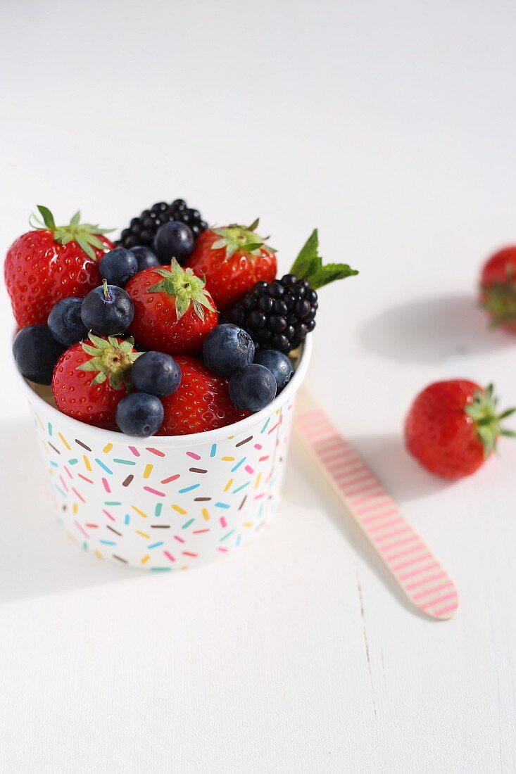 Various berries in a colourful tub