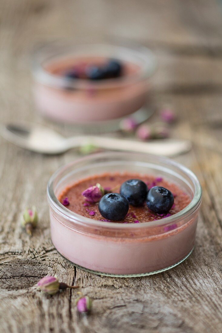 Crème brûlée with blueberries and rose petals