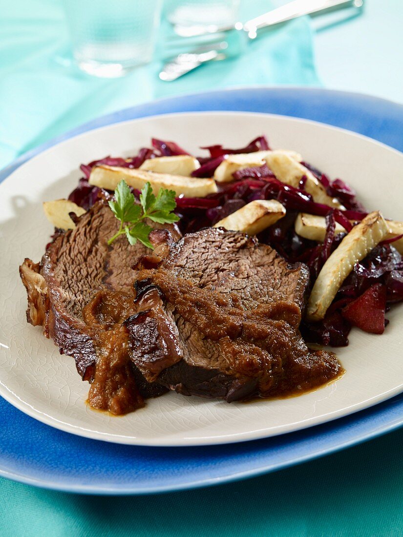Sauerbraten (marinated pot roast) with red cabbage and roasted celery