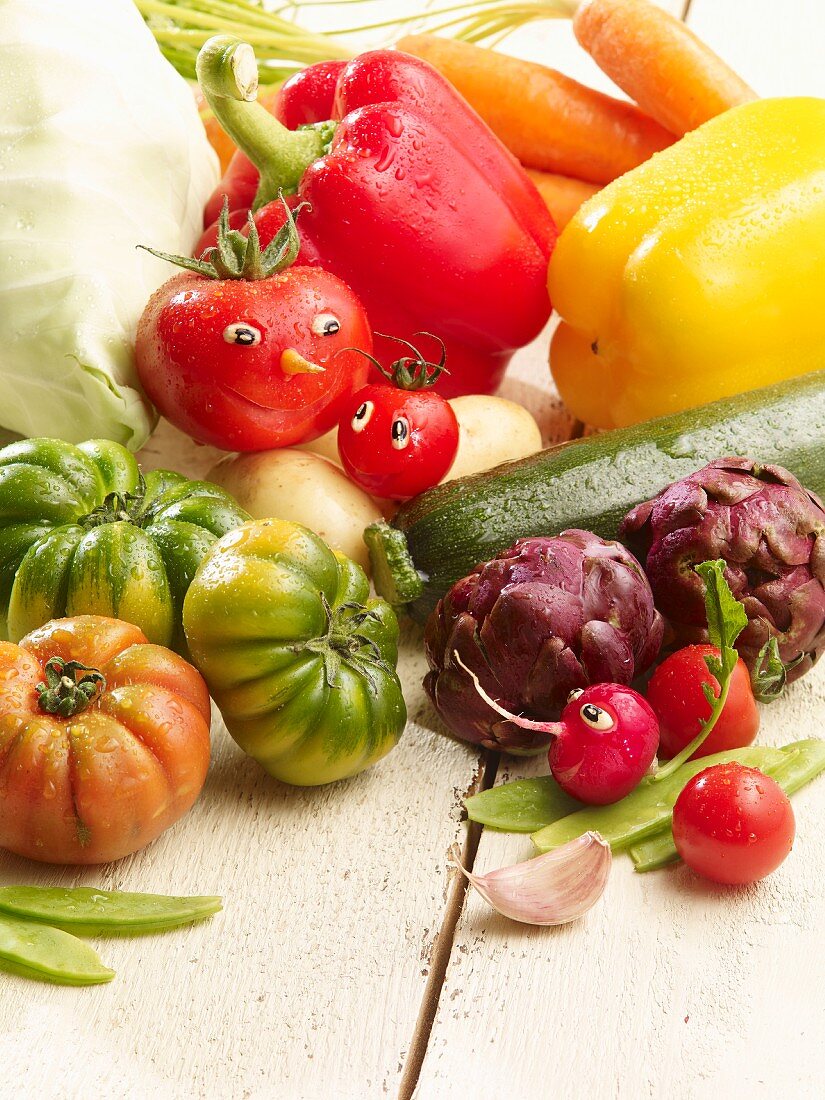 An arrangement of summer vegetables featuring tomatoes with faces