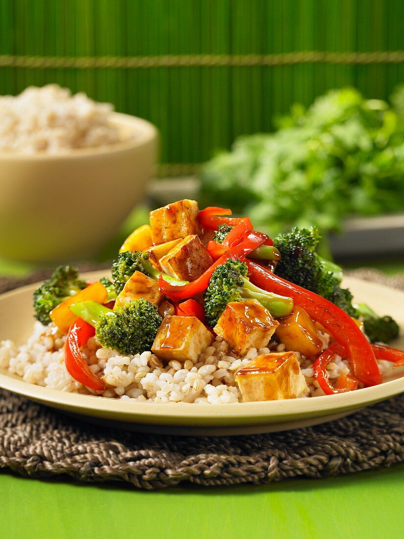 Sweet-and-sour fried tofu with pepper and broccoli on a bed of rice