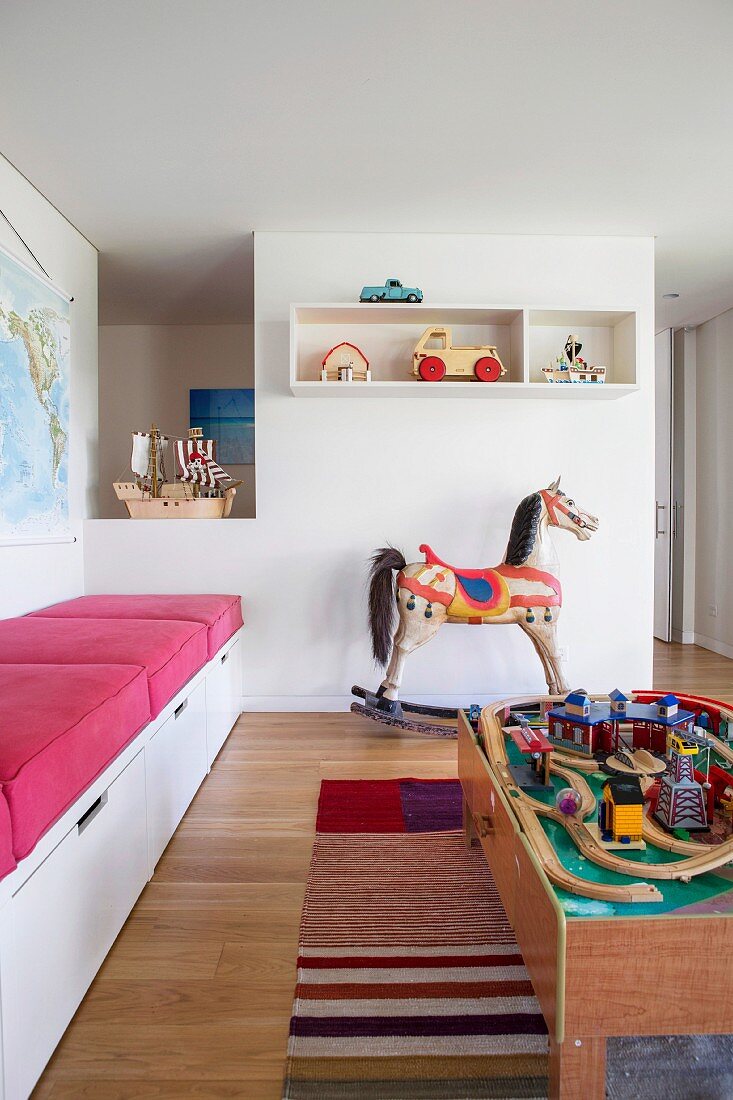 Play area with nostalgic rocking horse, wooden toys and built-in bench