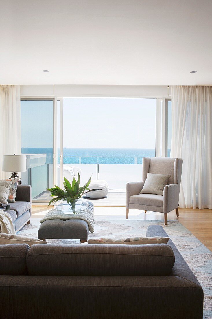 Elegant living area with open sliding patio doors, balcony and sea view