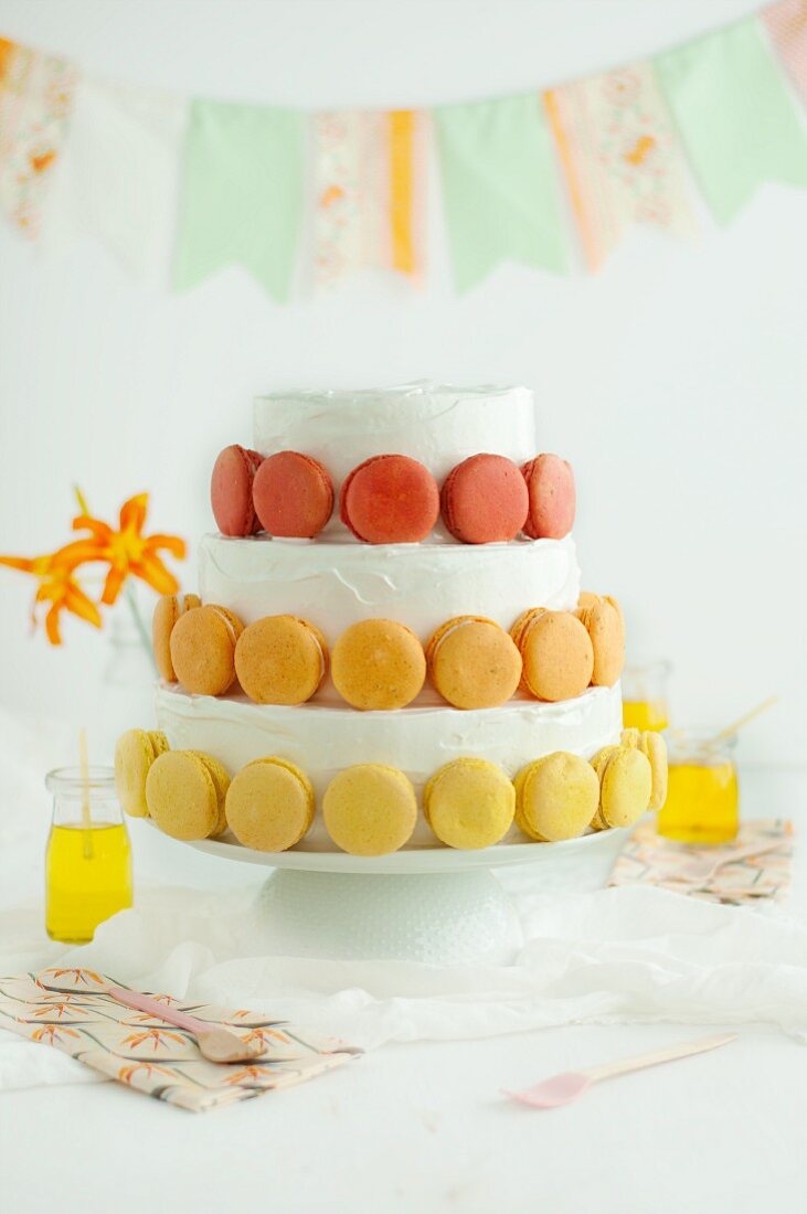A festive, three-tier cake decorated with macaroons