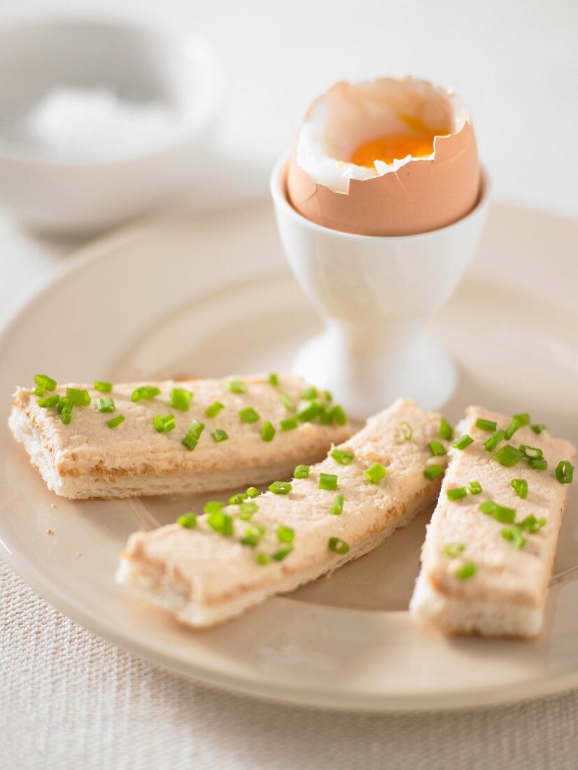 Weichgekochte Eier zu Brotstreifen mit Räucherforellencreme