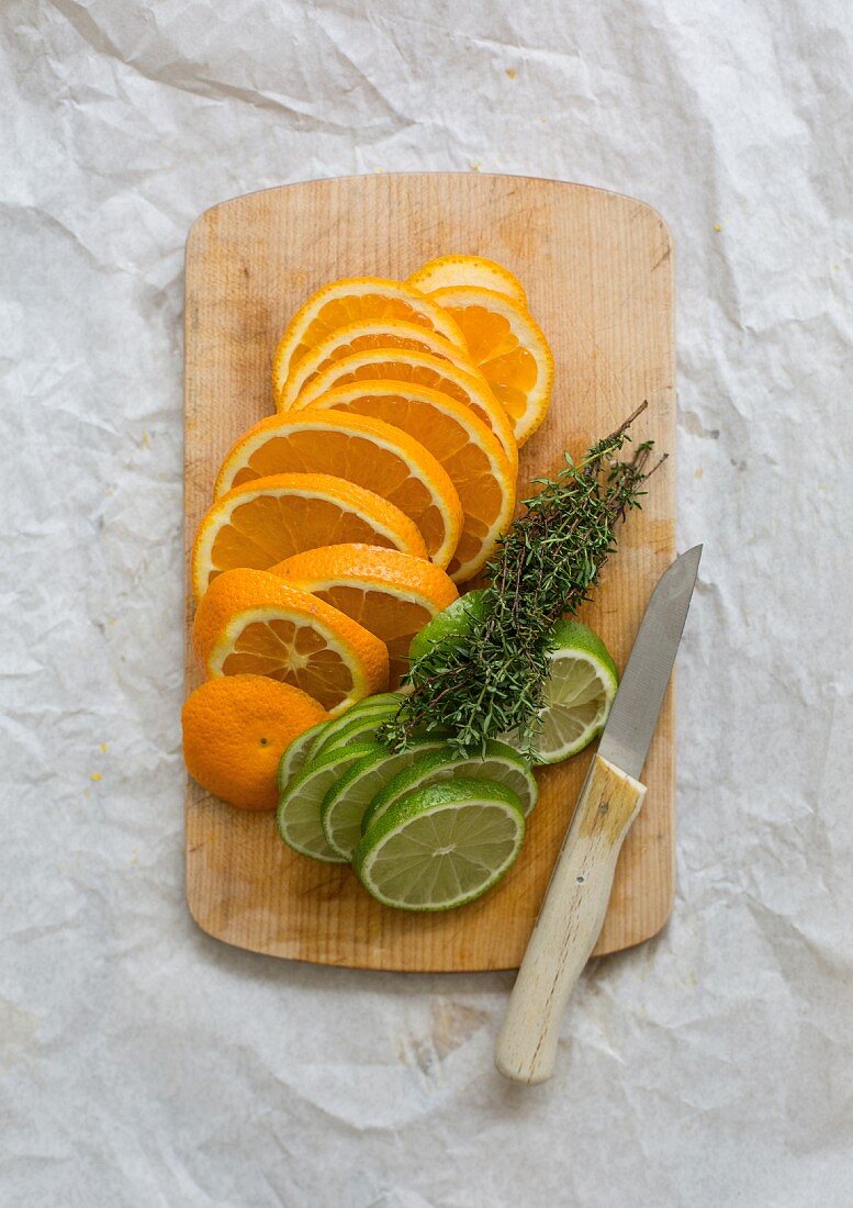 Orange and lime slices on a chopping board