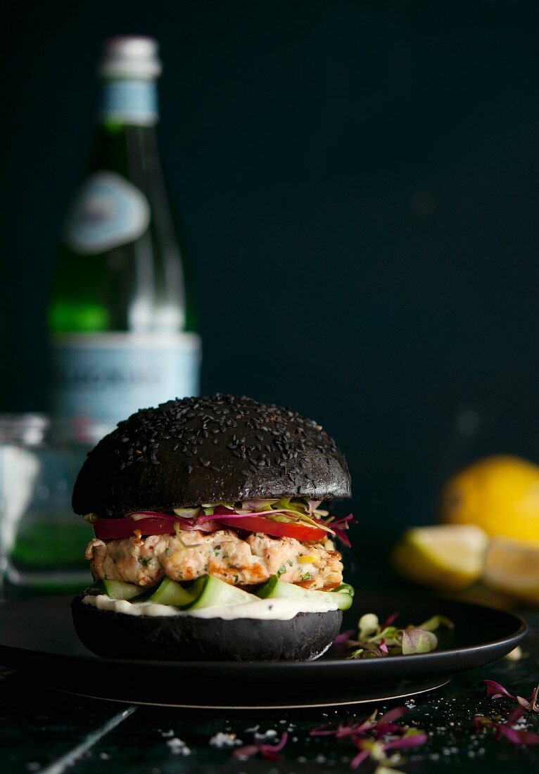 Salmon fillet on a black burger bun