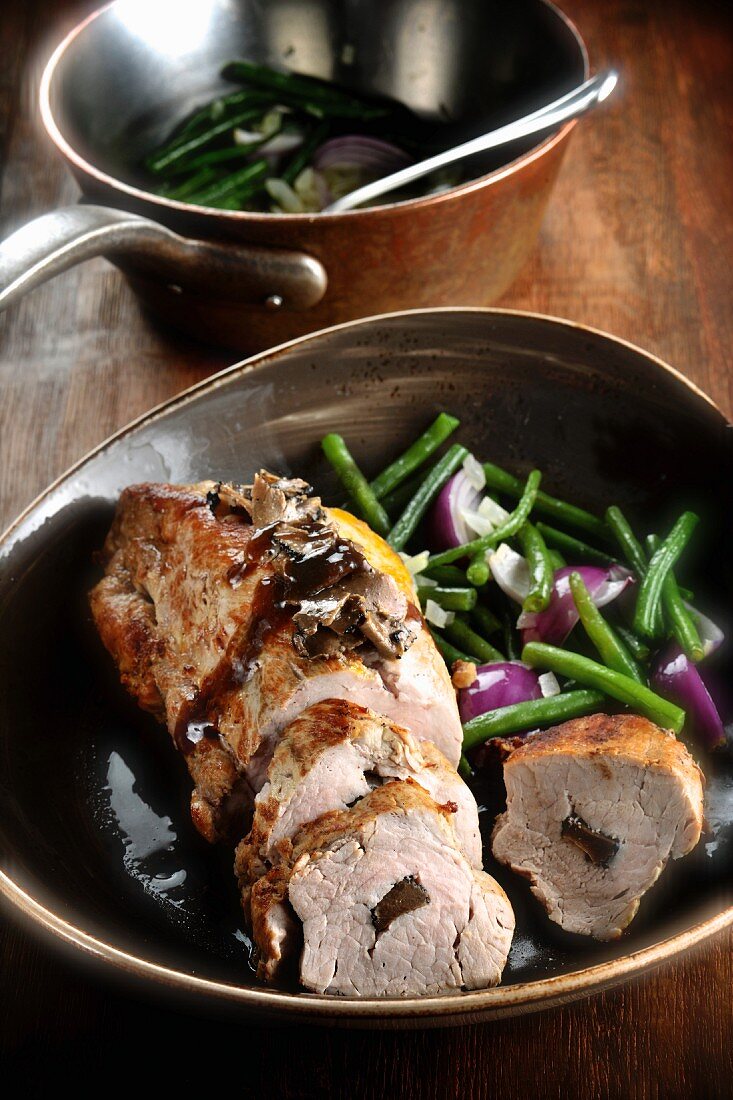 Gefüllter Schweinebraten mit Zwiebeln und Bohnen