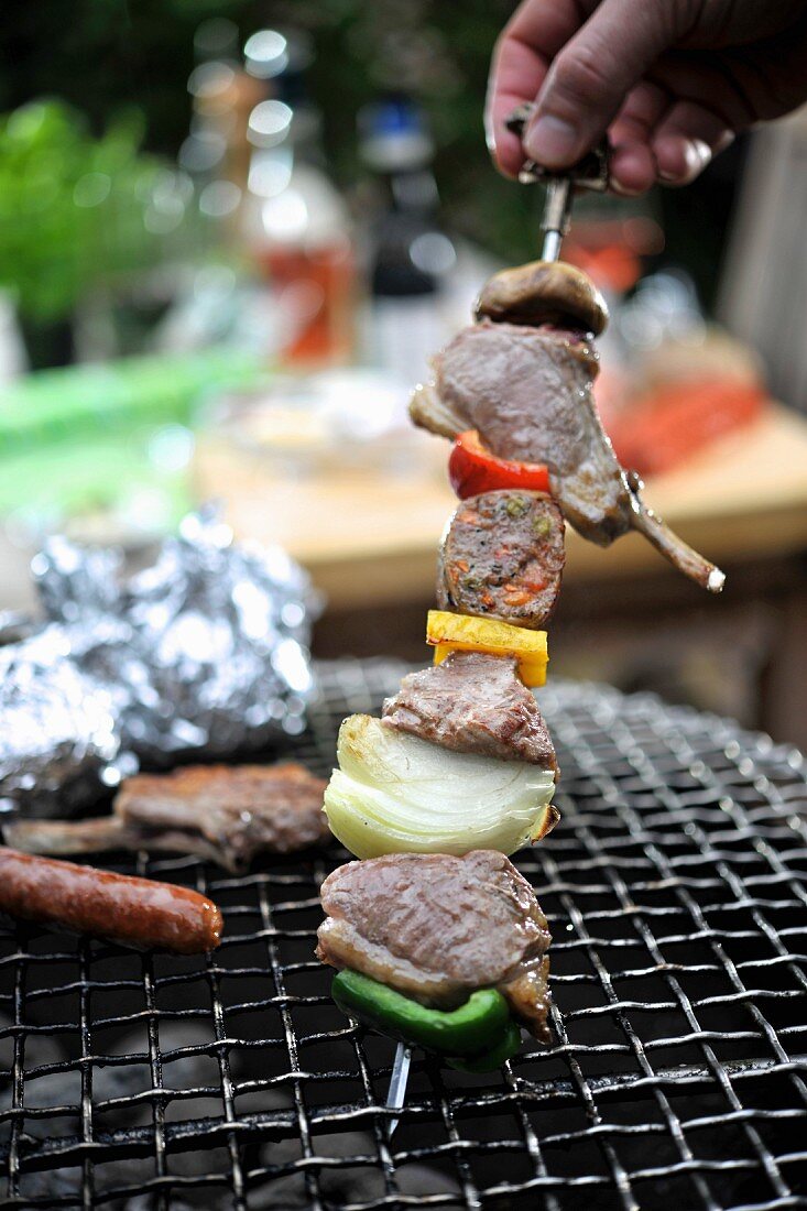 A meat kebab with peppers and onions on a barbecue