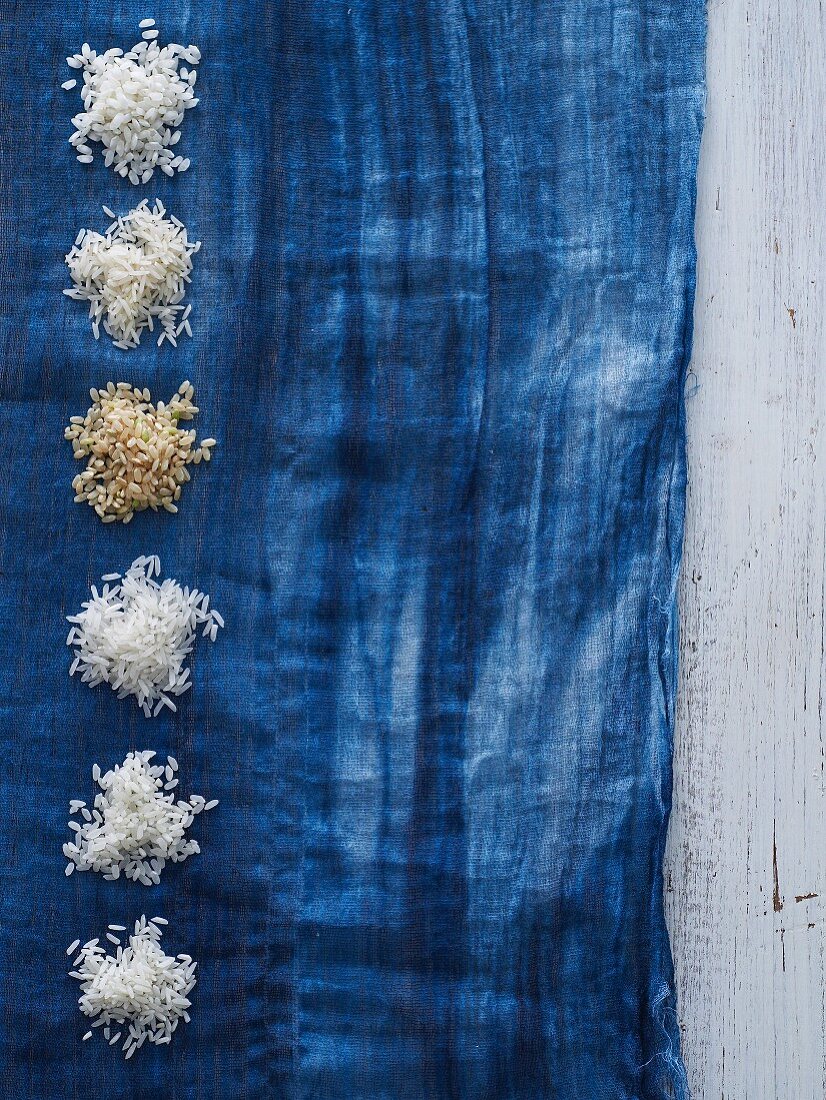 Verschiedene Reissorten auf blauem Tuch