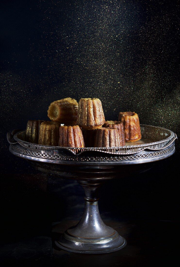 Cannelles being dusted with sugar