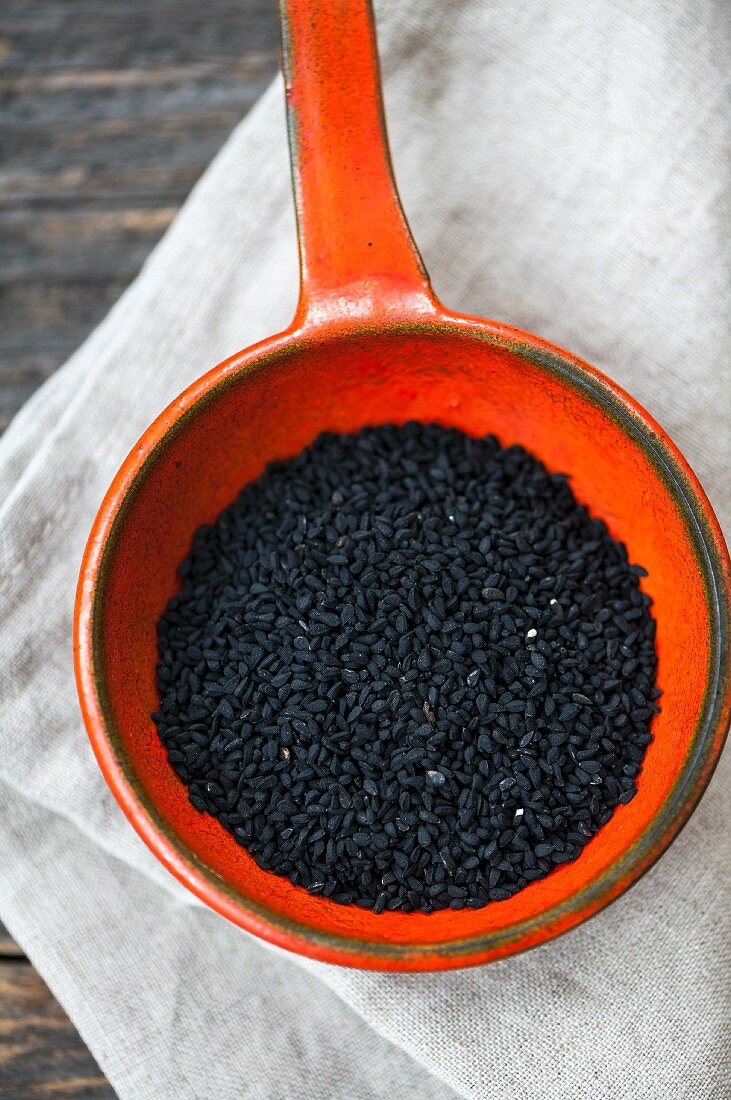 Black cumin in an orange container (seen from above)