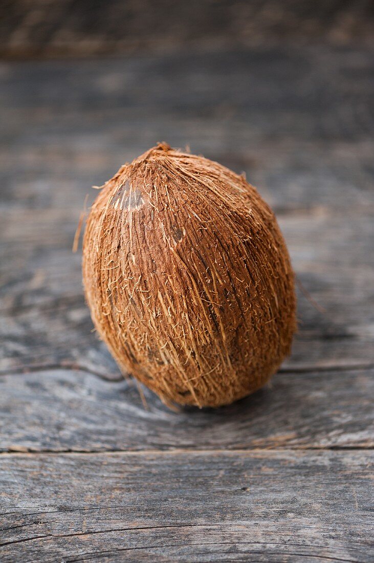 A whole coconut on a wooden surface