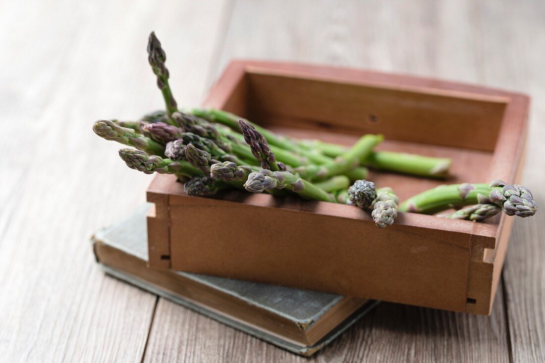 Green asparagus spears in a wooden box