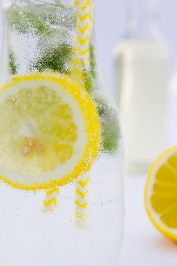 Zitronenlimonade mit Pfefferminze in Glasflasche (Nahaufnahme)