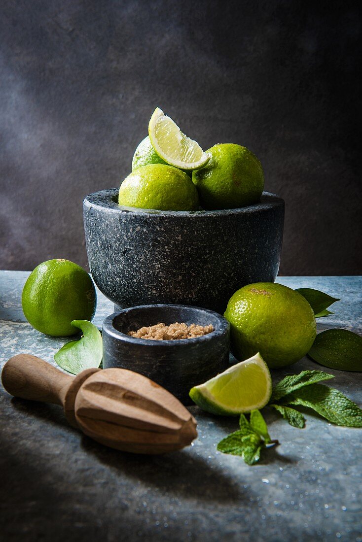 Cocktailzutaten für Mojito: Limetten, Minze und brauner Zucker