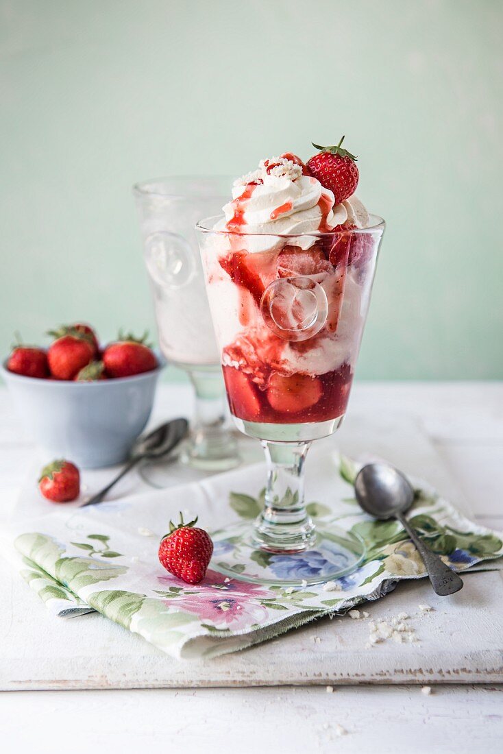 Ice cream sundae with strawberry ice cream, meringue and cream