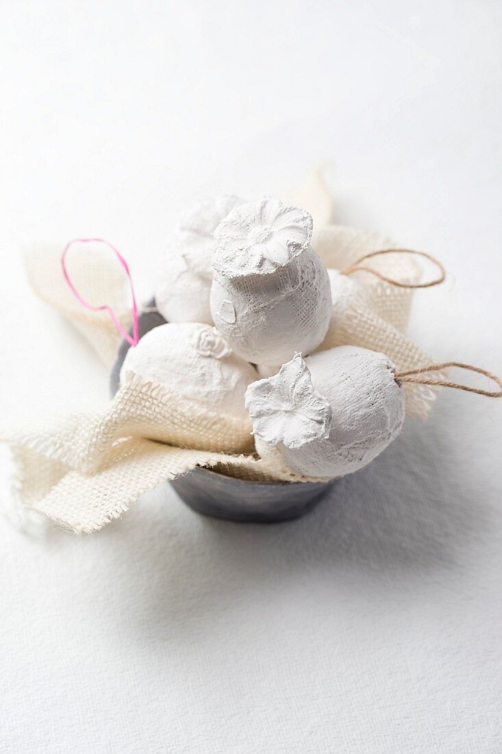 White Easter eggs made from plaster bandages decorated with plaster flowers