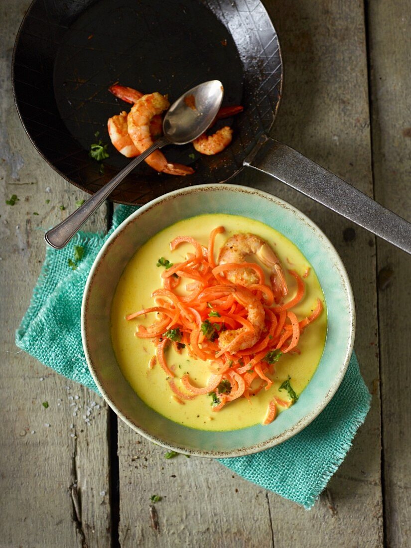 Coconut soup with carrot spirals and prawns