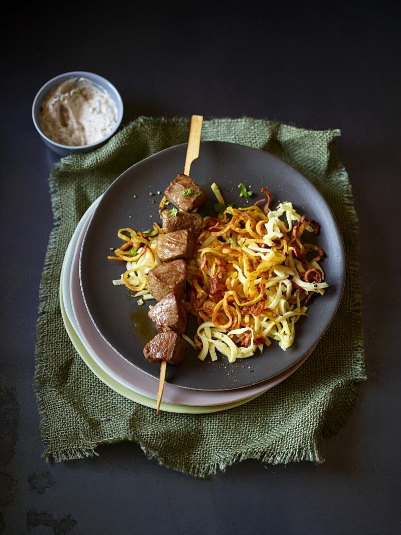 A lamb kebab on a bed of parsnip and potatoes spirals
