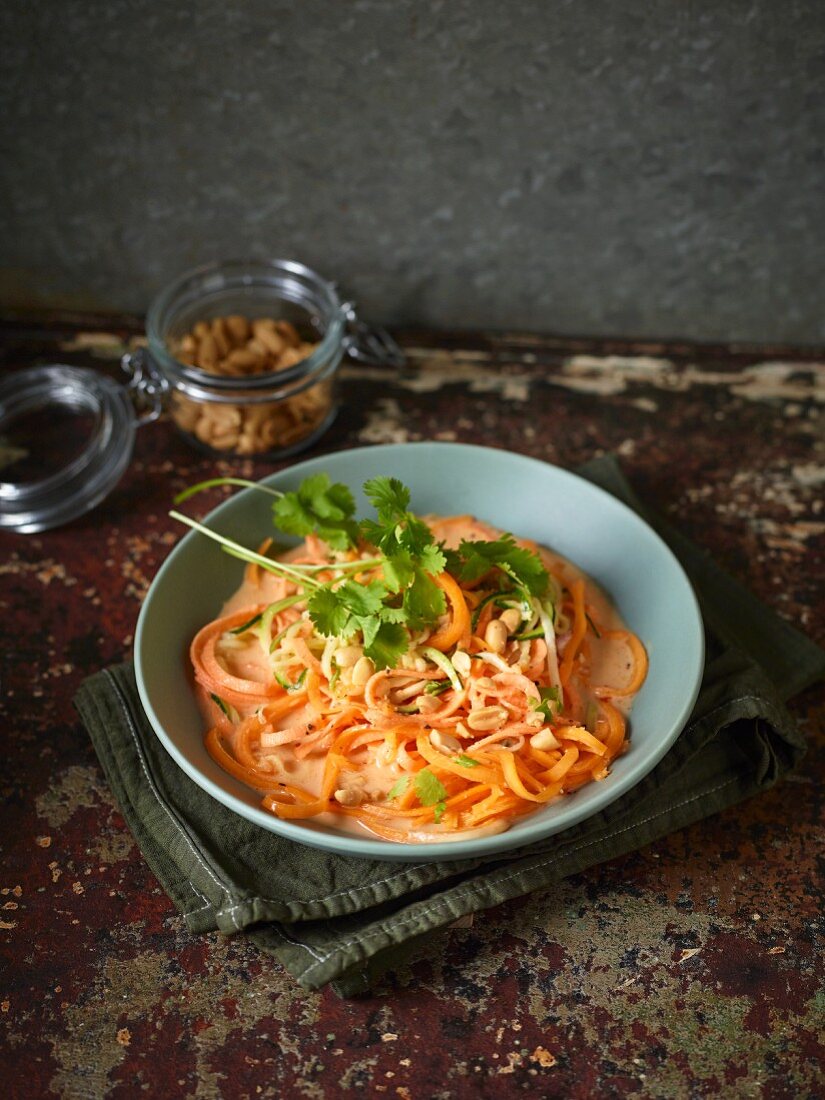 Thai coconut curry on a bed of vegetable noodles with peanuts