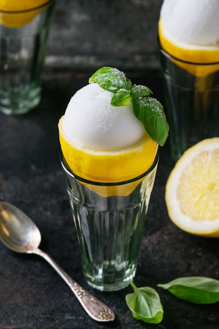 Lemon sorbet served in Apollo about lemon garnished with sugared basil leaves