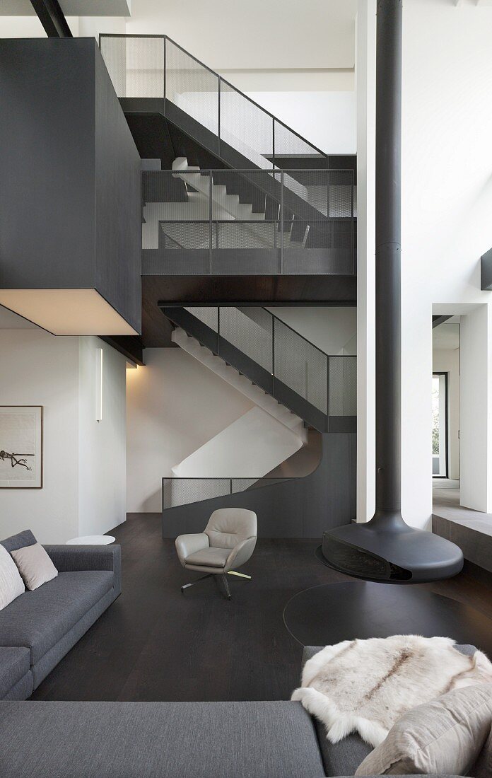 Extrahoher Raum in Schwarz-Weiß mit Treppen und hängendem Kamin