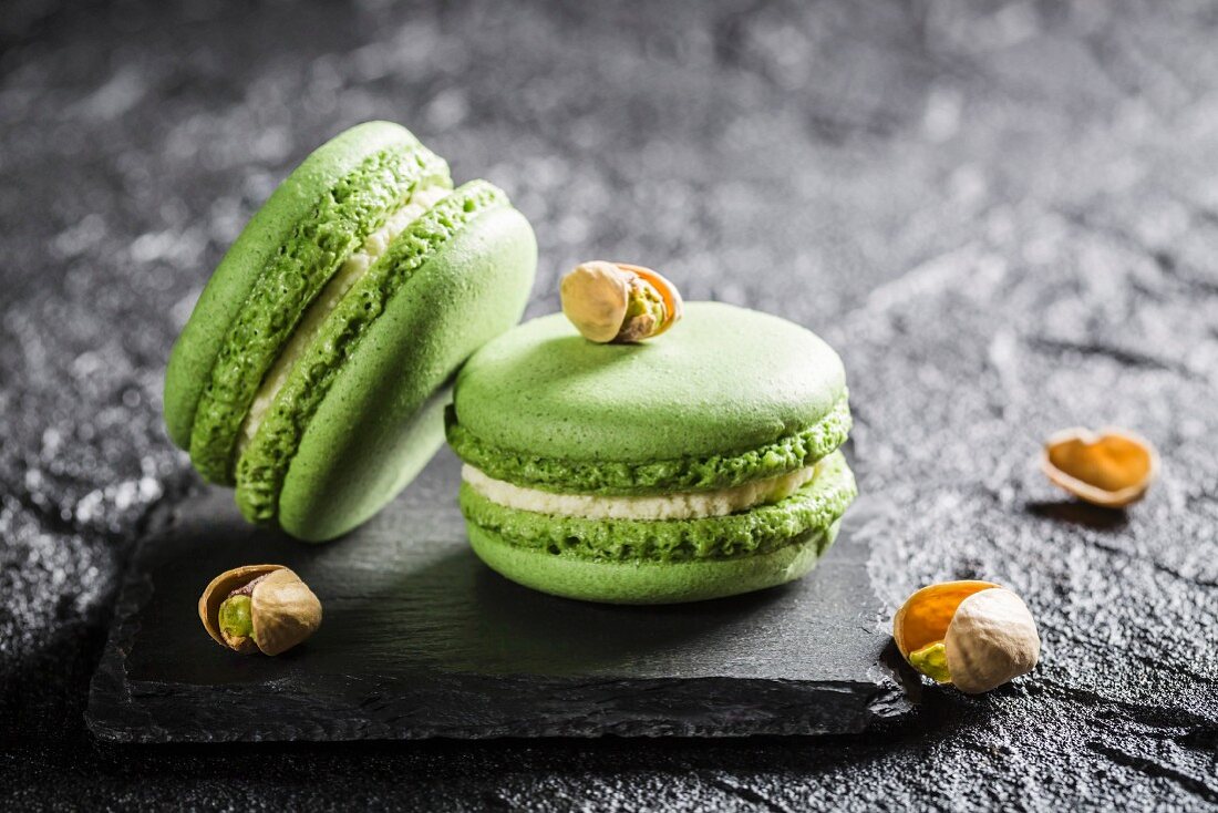 Pistazien-Macarons auf schwarzem Stein