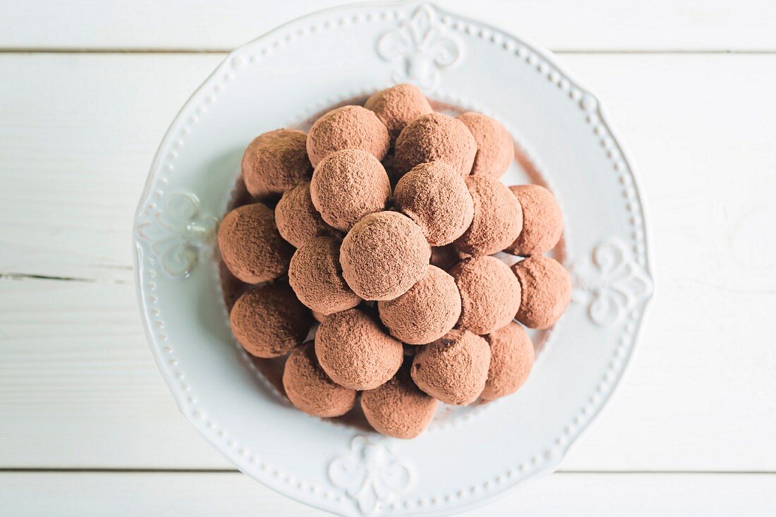A pile of chocolate pralines on a white plate