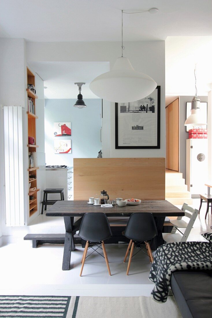 Rustic wooden table, bench and classic chairs in interior with raised platform