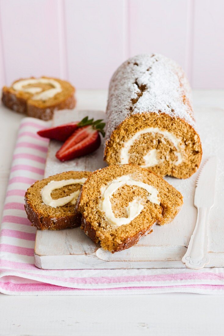 Ginger Swiss roll with icing sugar, sliced