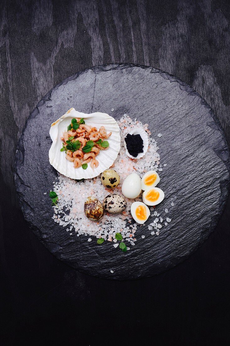 Quail's eggs, shrimps and caviar in a scallop shell