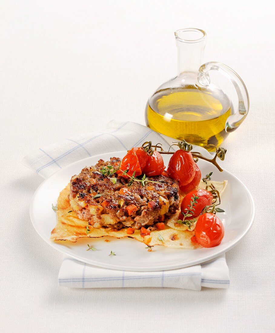 Hamburger auf sardischem Brot mit geschmorten Tomaten