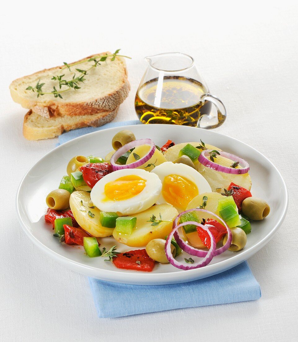 Warm potato salad with peppers, olives, onions and a soft boiled egg