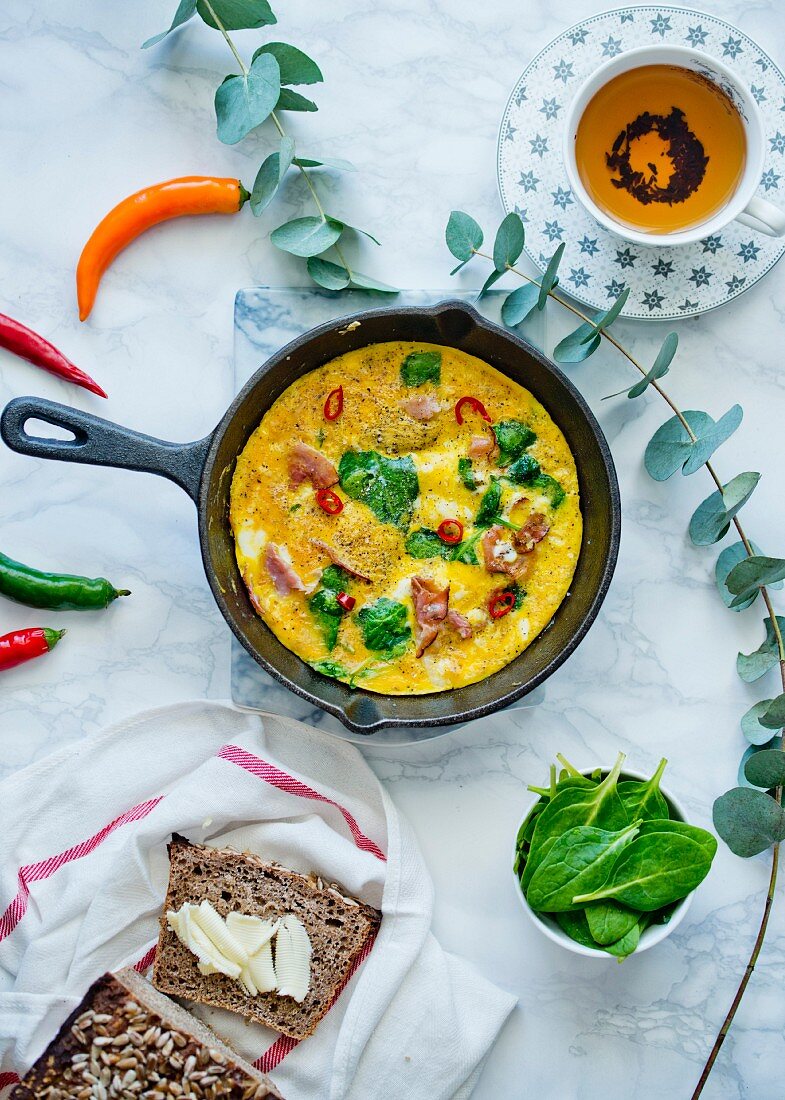 Omelette with spinach and ham in a small pan