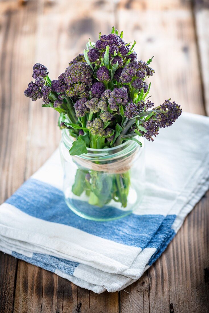 A bundle of purple sprouting broccoli in a jar