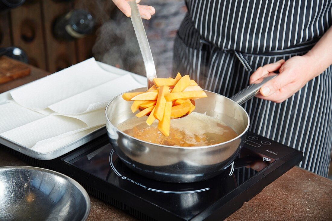 Sweet potato chips being fried in a pan
