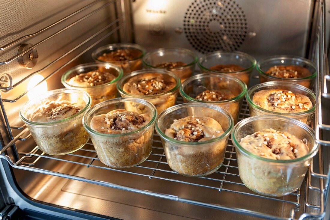 Glass bowls of rose cake in an oven