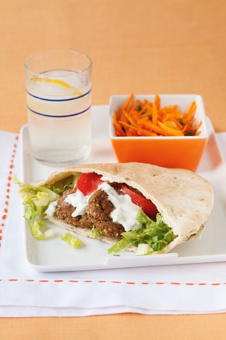 Falafel sandwich with lemon water and carrot salad