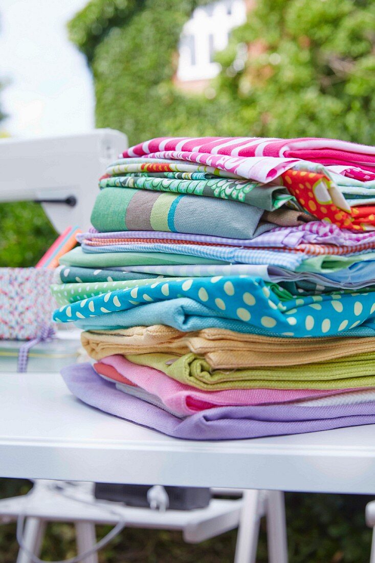 A pile of fabrics on a table outdoors