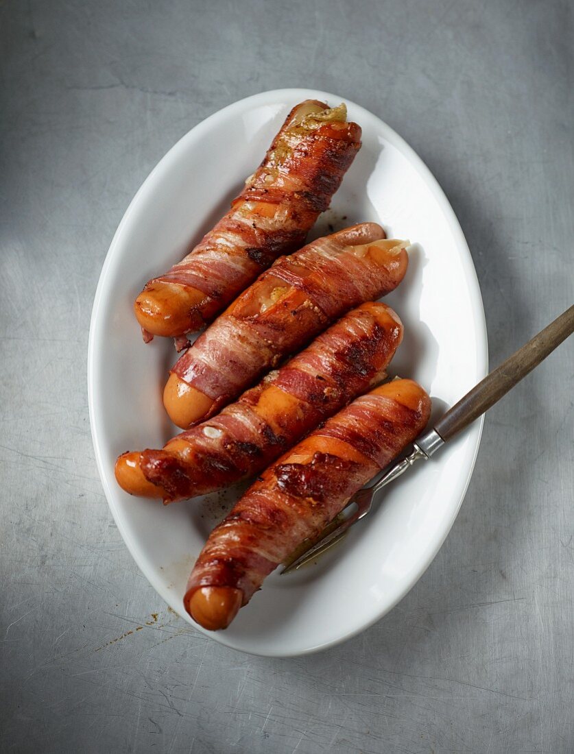 Fat, grilled Sauerländer sausages wrapped in bacon