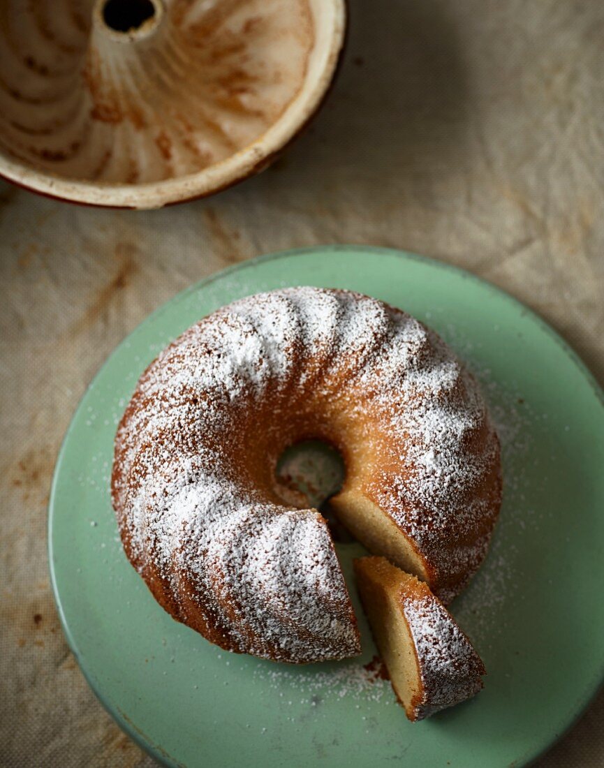 Eggnog Bundt cake dusted with icing sugar, sliced