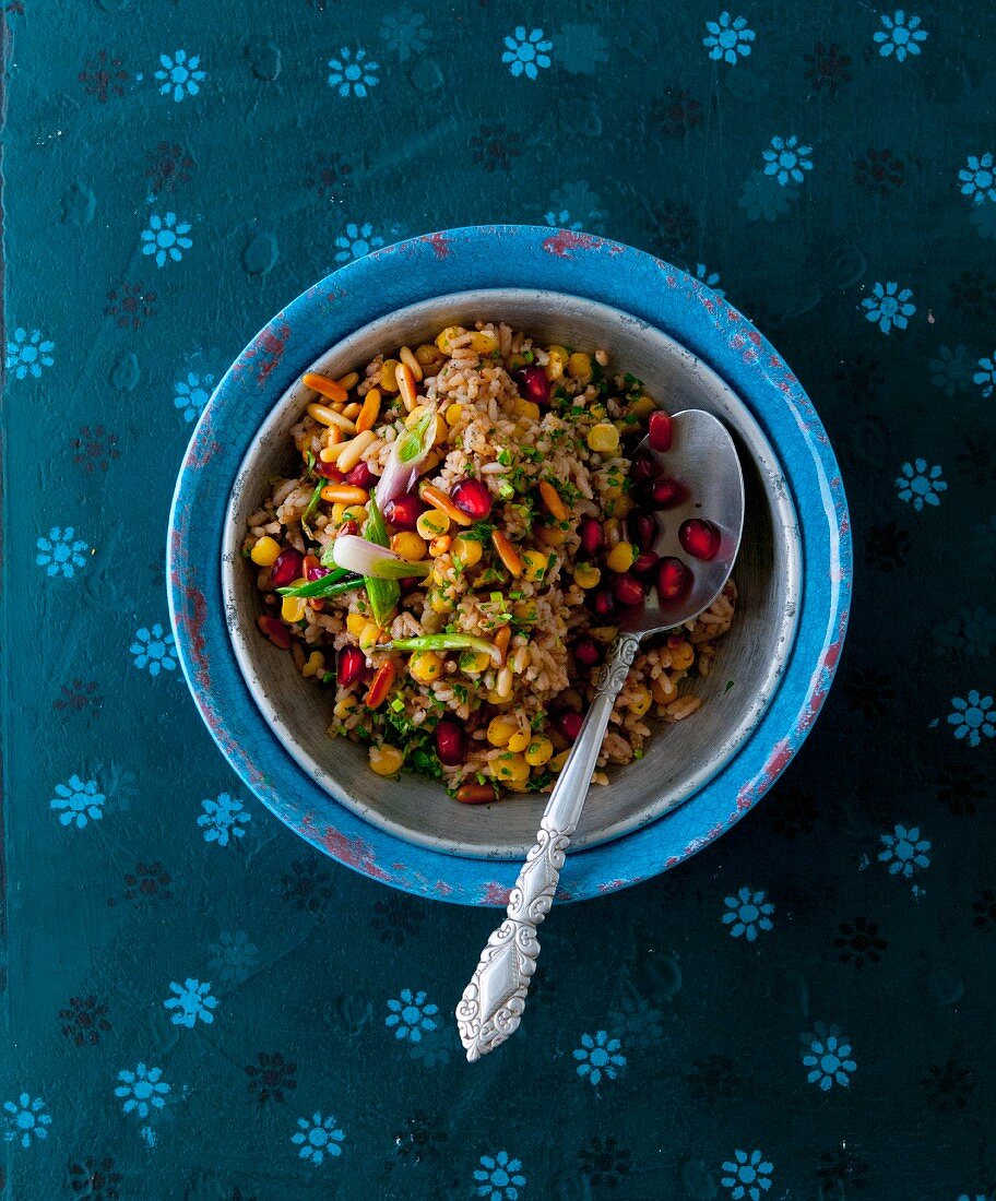 Oriental rice salad with pomegranate seeds and pine nuts