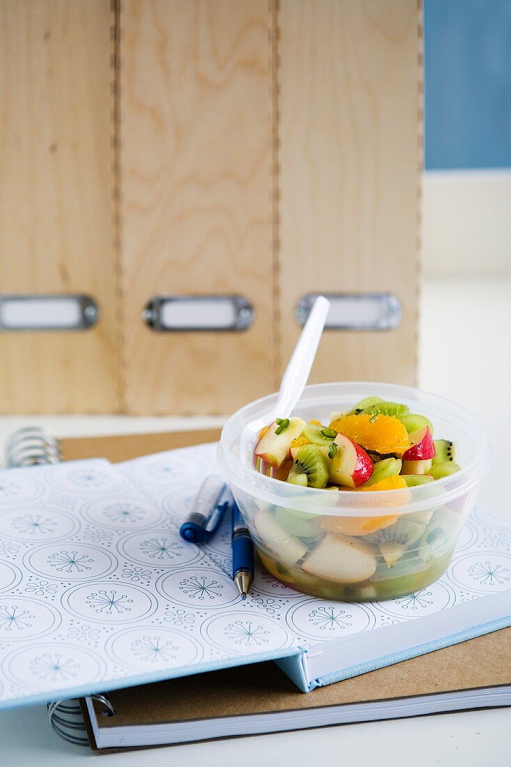 Obstsalat mit Zimt und Kardamom zum Mitnehmen in der Plastikbox