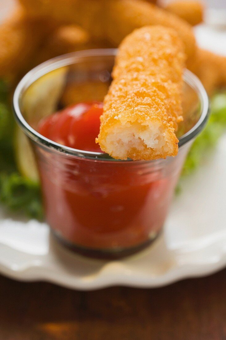 A home-made fish finger with a tomato dip (close-up)