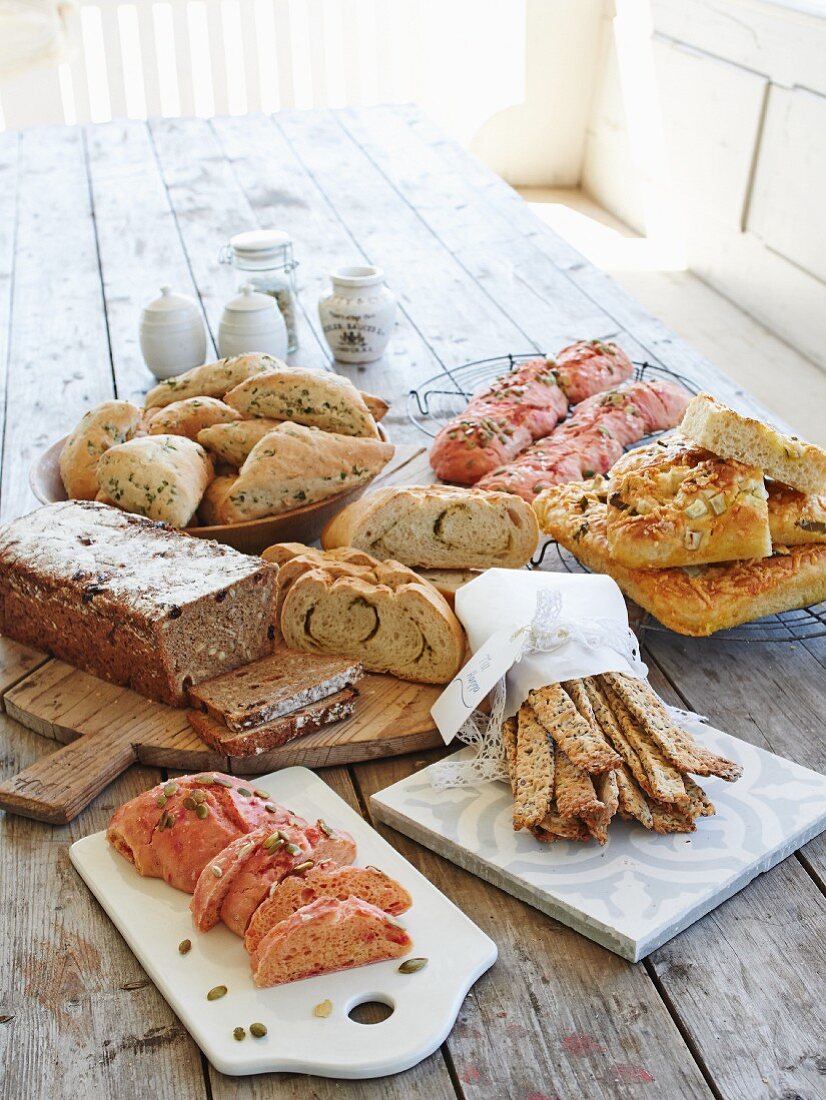 Verschiedene selbstgebackene Brote und selbstgebackenes Gebäck auf Holztisch