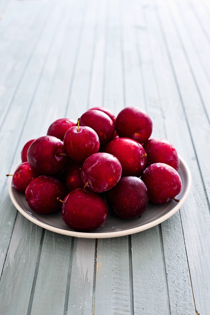 Fresh plums in white bowl